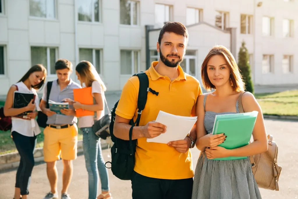Two happy students with backpacks